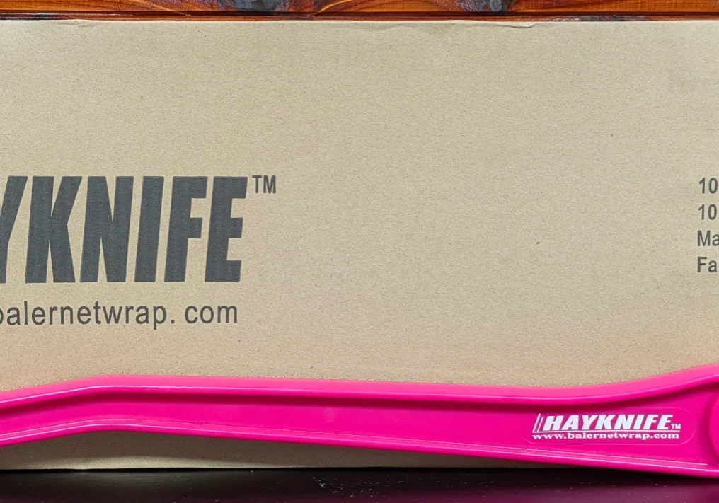 Close-up of a pink Hayneedle knife on a beige surface.